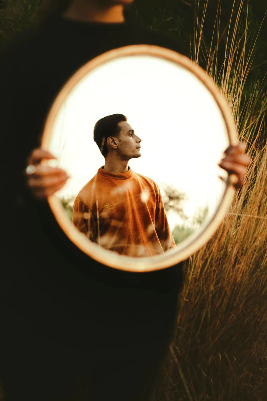 Sagar Shabbir reflected in round mirror at golden hour