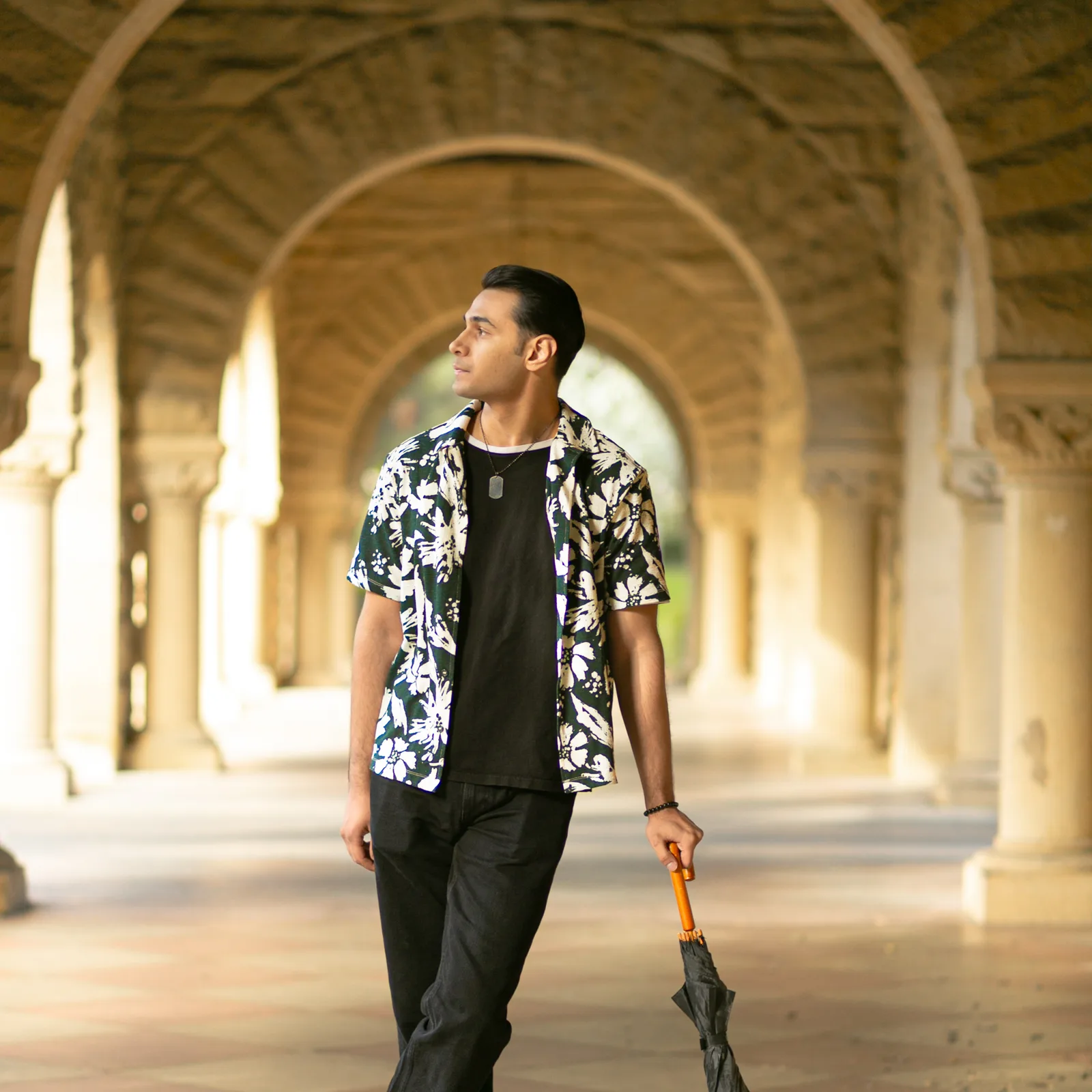 Sagar Shabbir walking in arched corridor, looking to side