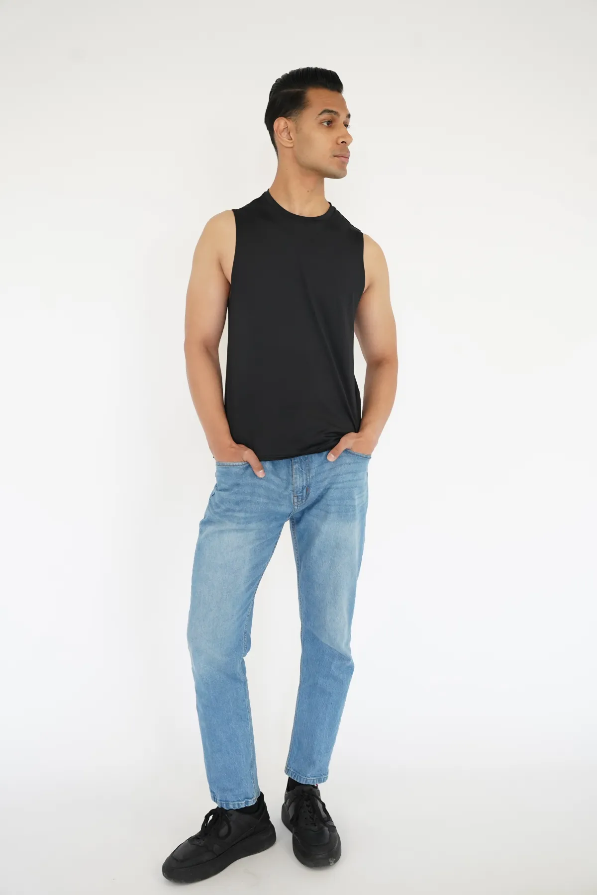 Sagar Shabbir — digital, full-length, black sleeveless top and light jeans, studio white background