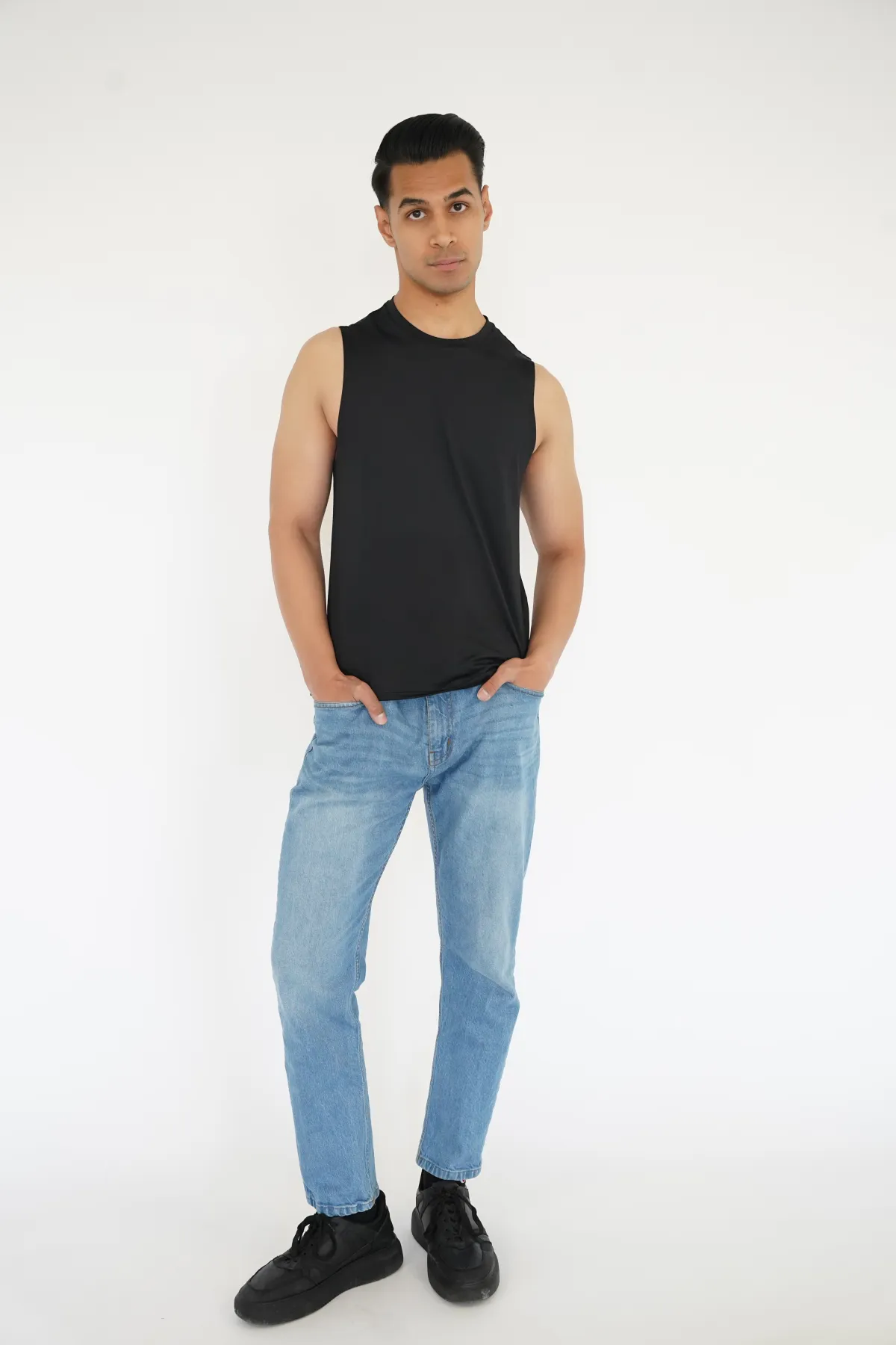Sagar Shabbir — digital, full-length front, black sleeveless top and light jeans, studio white background