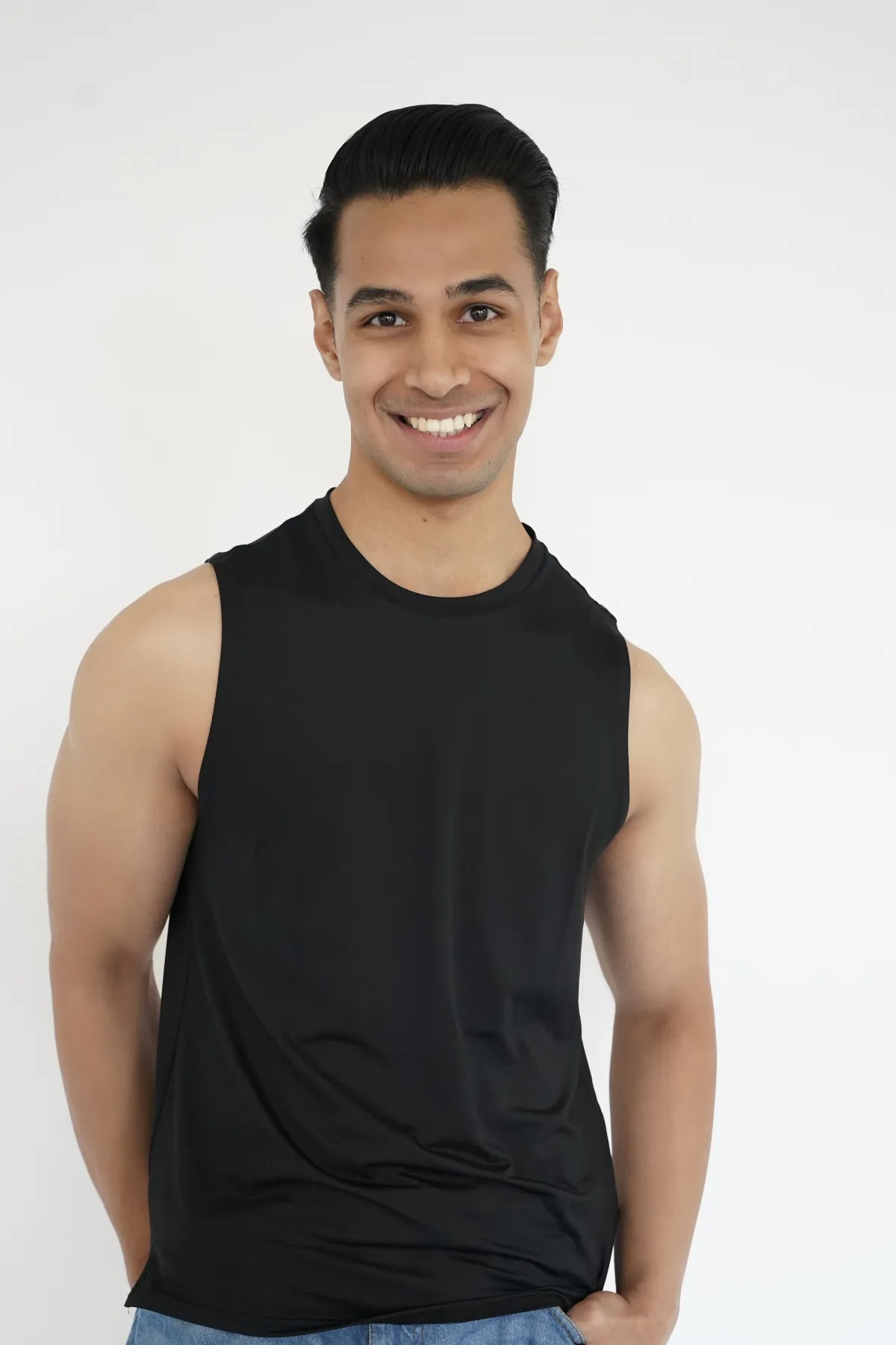 Sagar Shabbir — digital, headshot smiling, black sleeveless top, studio white background