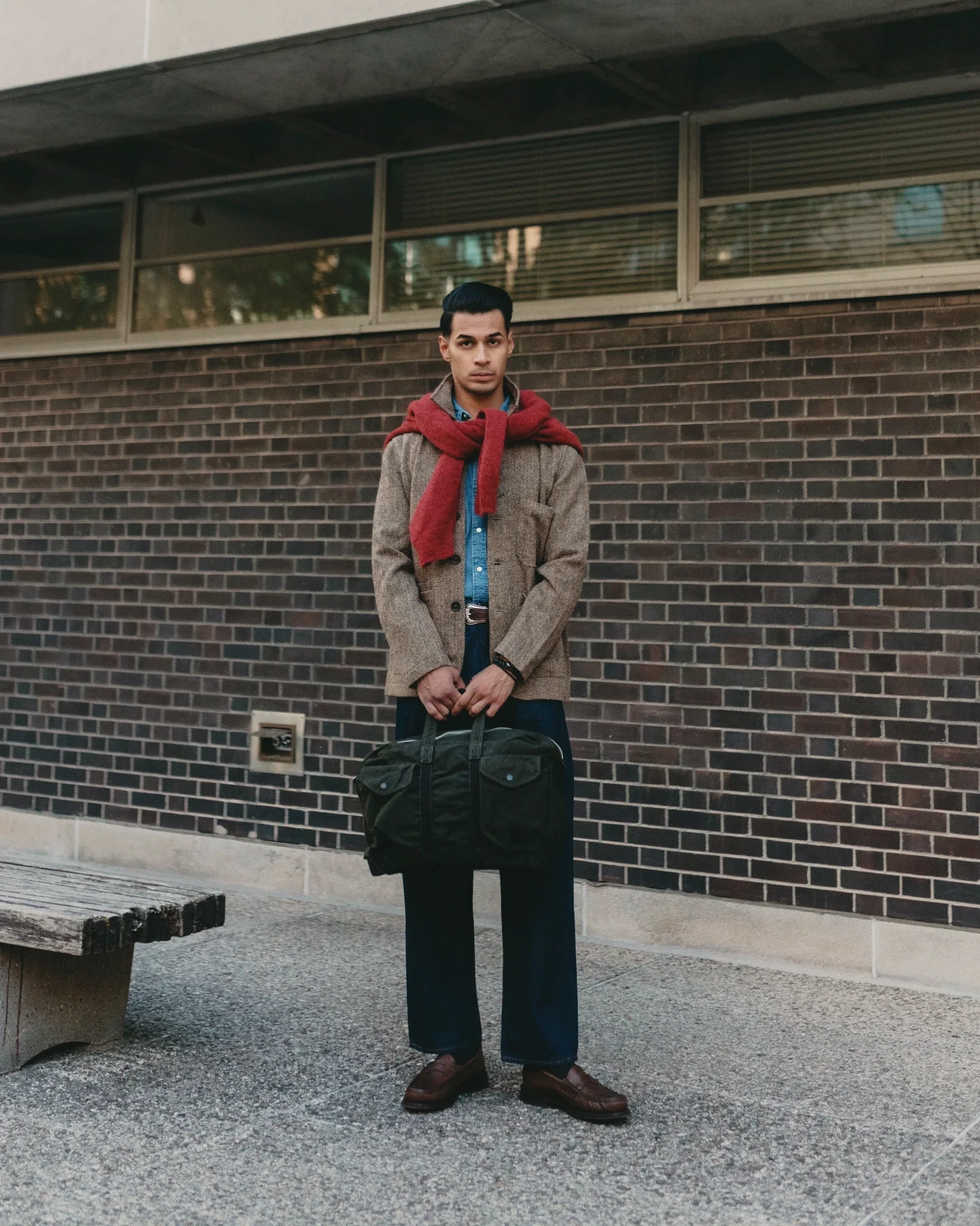 Sagar Shabbir — tweed jacket with red scarf and denim, holding waxed bag, street editorial